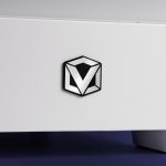 Geometric V logo on a white surface, modern metallic design with black accents, close-up angle